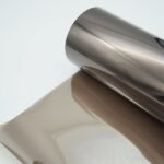 Pakankamai tamsi, veidrodinio bronzinio/rudo atspalvio plėvelė, šviesos laidumas 23%